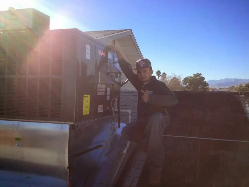 HVAC technician performing Heat Pump Repair on a rooftop unit in Centerville